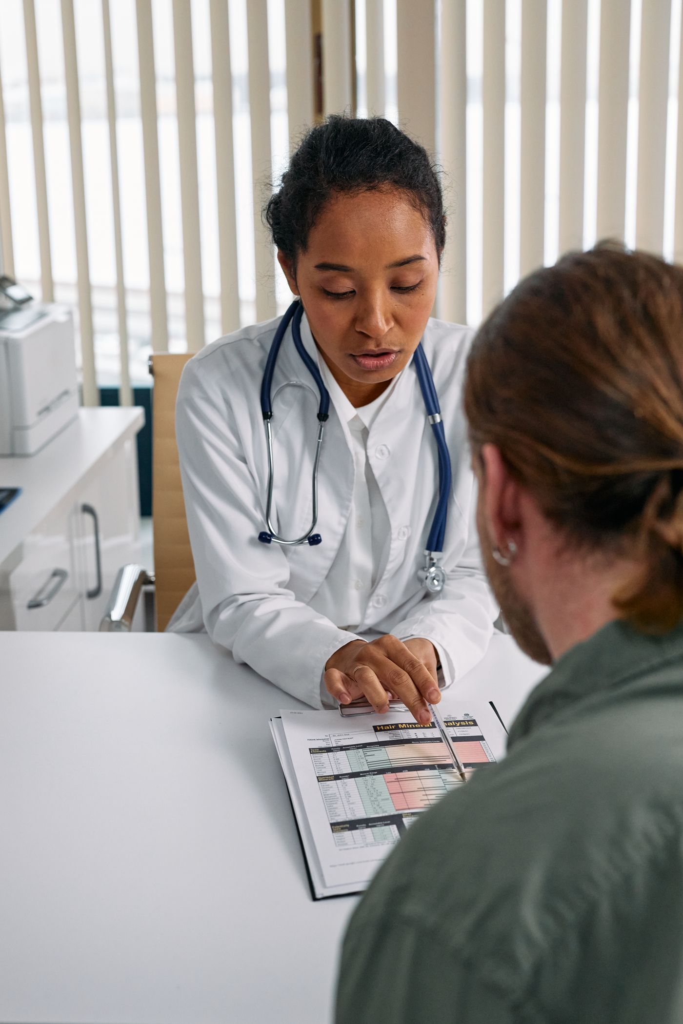 Physician discussing a health chart with a patient during a consultation